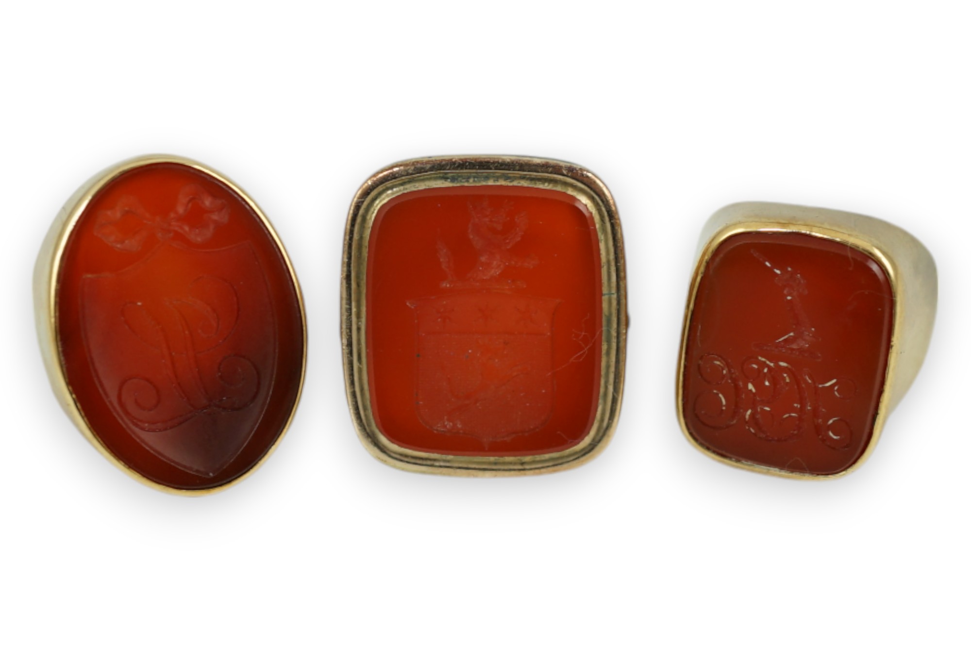 A Victorian 9ct and carnelian set intaglio ring, carved with a crest size L and two other similar yellow metal and carnelian intaglio ring, gross weight 35.8 grams.